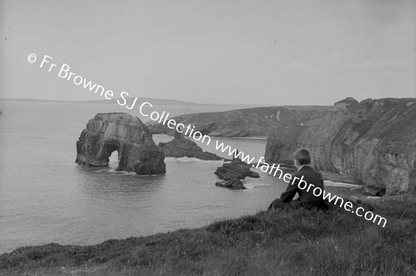 STRAND AND CLIFF SCENE WITH MAN